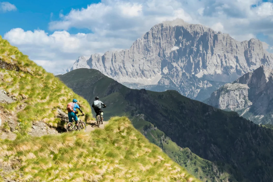 Cyclists with a view of Mount Civetta peak.