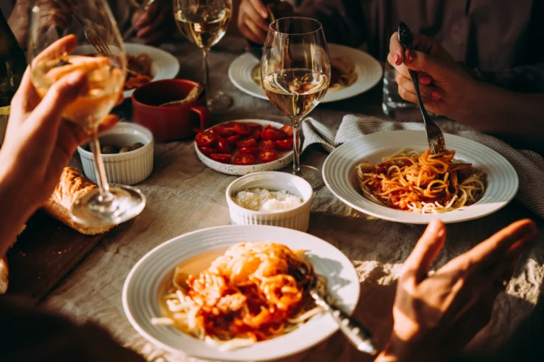 Group of people having traditional Italian food at mountain rifugio.