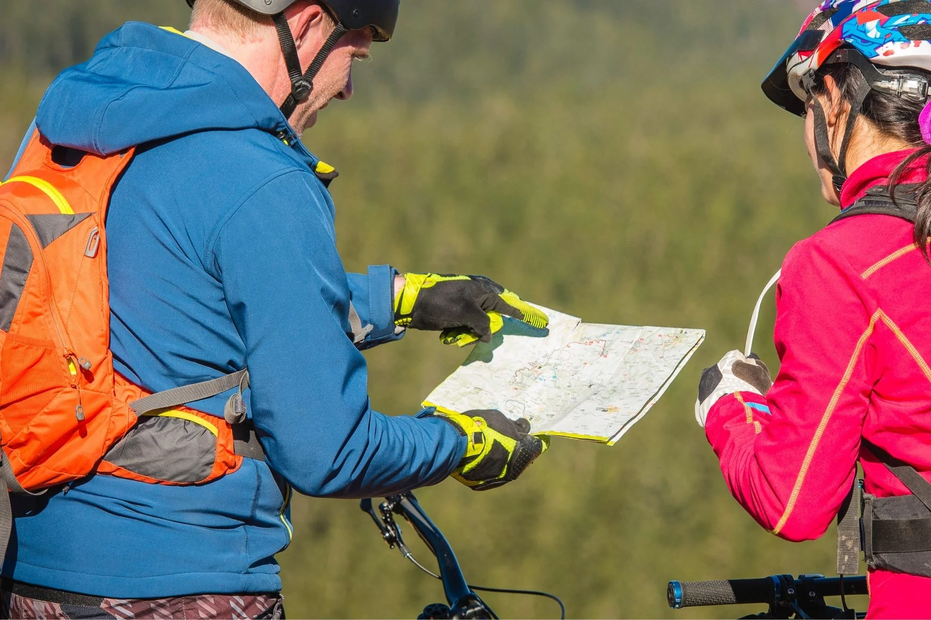 Two cyclists looking at a paper map.