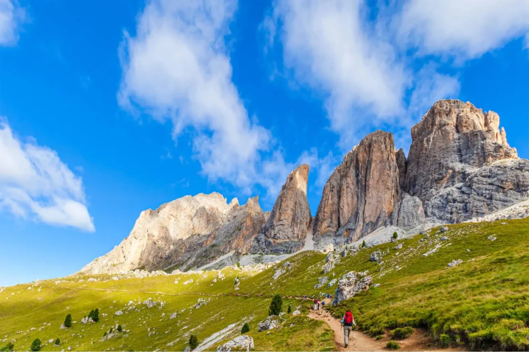 Hikers on a path at the Sassolungo Group.