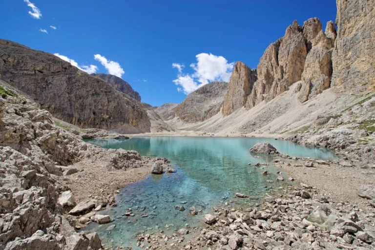 Lake Antermoia's aqua coloured water surrounded by lunar landscape like terrain.