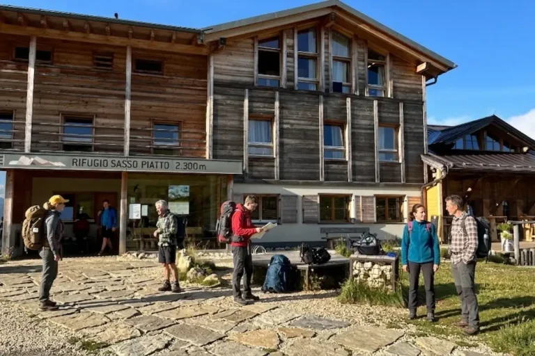 Rifugio Sasso Piatto in the morning, with a few hikers getting ready to depart.